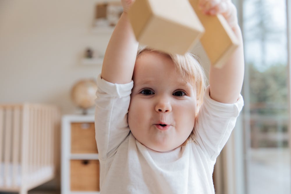 Joyful Child Playing With Wooden Blocks