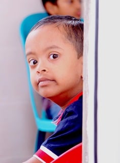 Curious Child Peeking Around A Wall